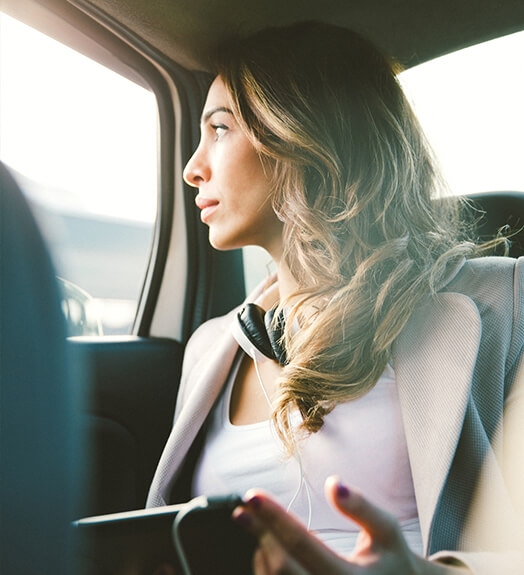 Uber passenger with headphones in the back seat